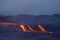 Hot landscape of an erupting volcano with fresh lava coming ot from the crater