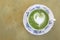 Hot matcha green tea heart shape foam on marble table background