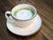 Hot matcha green tea latte with milk foam cup on wood table at cafe. Trendy powered tea trend from Japan - Healthy drink