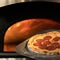 Hot pizza freshly baked. Ready to eat pepperoni pizza with salami against of open burning fire in oven or stove on