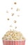 Hot popcorn falling into paper bucket on background