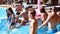 Hot pretty girls in bikini walking with floaties into swimming pool to join the party with friends. Happy young people