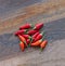 Hot red pepper mini chili pods on wooden background