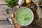 Hot rich meat broth with herbs on a rustic table. Top view flat lay background