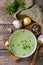 Hot rich meat broth with herbs on a rustic table. Top view flat lay background