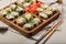 Hot rolls with eel, Japanese omelette, cream cheese, fried onions and unagi sauce, decorated with fresh herbs. Japanese food on a