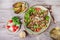 Hot salad with veal, mushrooms, salad leaves, eggplant, zucchini, tomatoes, garnished with grated almonds and Parmesan cheese