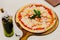 Hot served Pizza Margherita on wooden plate with olive oil