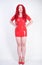 Hot sexual redheaded girl with plus size body wears fashion latex rubber red dress and posing on white studio background alone. ch