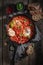 Hot shakshuka with tomatoes, eggs and herbs