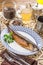 Hot smoked herring fish on plate and glass of lemonade on oriental wooden table