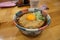 Hot soba with deep fried egg with onion in Japanese bowl on timber table