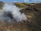 Hot spring with boiling water rising from rocks in Landmannalaugar colorful Rhyolit mountains on famous Laugavegur trek