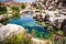 a hot spring surrounded by wildflowers and rugged boulders