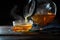 Hot steaming tea is poured from a pot into a glass cup, served with a stick of rock candy, motion blur, dark rustic wooden