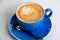 Hot and steamy cappuccino in bright blue cup