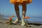 Hot Summer beach with legs and cute colorful girly flower printed motif plastic boots - generative AI