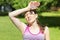 Hot summer weather. girl covering her head from sunshine with hand in pain. young woman with bottle of water from thirst on sun.