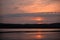 Hot sunset above the forest. Refelctions of red clouds in the water of the lake. bright colors at the end of a summer day