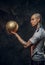 Hot tattooed, bald fashionable male soccer player posing in a studio for the photoshoot with a soccer ball