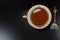 Hot tea cup white porselain with spoon,at black wooden background / teatime