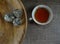 Hot tea cup white porselain with tea flowers and burlap/hessian at wooden background