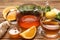 Hot tea, honey, ginger and citruses on wooden table