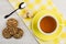 Hot tea and lump sugar on yellow napkin, cookies