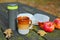 Hot tea, mug, apples and book on a picnic table on a fall day