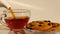 Hot tea pouring into glass cup. Close up slow motion.