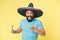 Hot tempered people. Man shouting face in sombrero hat yellow background. Guy with beard looks annoyed or angry in