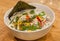 Hot thai soup with noodles, coconut milk and vegetables in white plate. Asian dish, typical in restaurants of Thailand