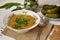 Hot vegetable soup in a plate, bread and cucumber. Close-up