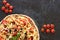 Hot vegetarian pizza with tomatoes, bell pepper, onion, olives, cheese, spices on dark baking tray background with copy space