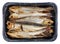 Hot whole smoked capelin saury sprat Baltic sea fish with heads and guts in plastic box