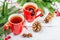 Hot winter or Christmas tea in ceramic red cups. Fir tree branches, lemon slice, spices and berries