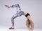 A hot woman practicing yoga asana bridge pose with leg up. White background side view. Yoga training and pilates idea