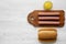 Hotdog ingredients: sausages on wooden board, hot-dog buns and mustard on white wooden surface, top view. Flat lay, overhead, from