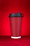 A hotdrink paper cup on a red background vertical composition