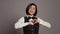Hotel administrator shows heart shape symbol on camera