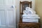 Hotel bathroom decor closeup. White towels,  on wooden stool and a door. Natural colors, still life. Studio shot