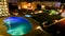 Hotel with illuminated swimming pool at night