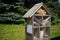 Hotel for insects on a background of trees, a wooden house for bees