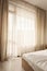 Hotel interior. Long beige curtains and tulle curtains, sheers on a window in the bedroom. Interior design concept
