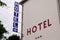 Hotel light arrow sign blue and red text and three stars on Building in tourist city