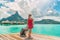 Hotel luxury resort tourist woman arriving with luggage suitcase in Tahiti Bora Bora honeymoon vacation travel on