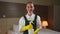 Hotel maid in uniform and rubber gloves holds detergent