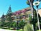 Hotel park with exotic trees and building adorned with blooming bougainvillea