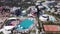 Hotel Poolside with Parasols and Palms. Clip. Top view shot. Swimming Pool surrounding palms and green garden in the