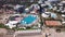 Hotel Poolside with Parasols and Palms. Clip. Top view shot. Swimming Pool surrounding palms and green garden in the